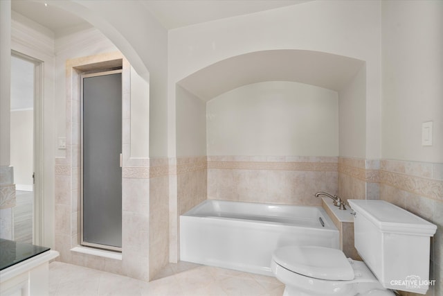 bathroom featuring tile walls, independent shower and bath, tile patterned floors, and toilet