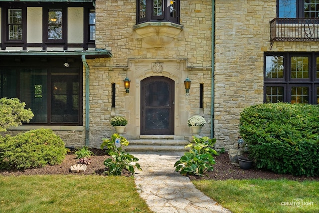 view of exterior entry featuring a balcony