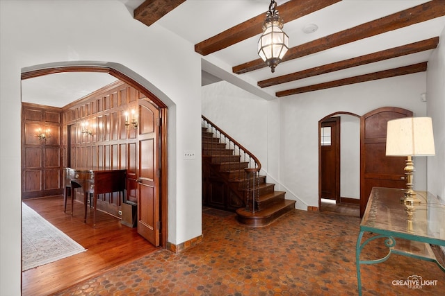 entrance foyer featuring dark wood-type flooring and beamed ceiling