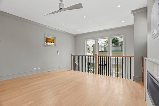 unfurnished room with crown molding, ceiling fan, light hardwood / wood-style flooring, and a fireplace