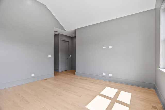 unfurnished room featuring light hardwood / wood-style floors and vaulted ceiling