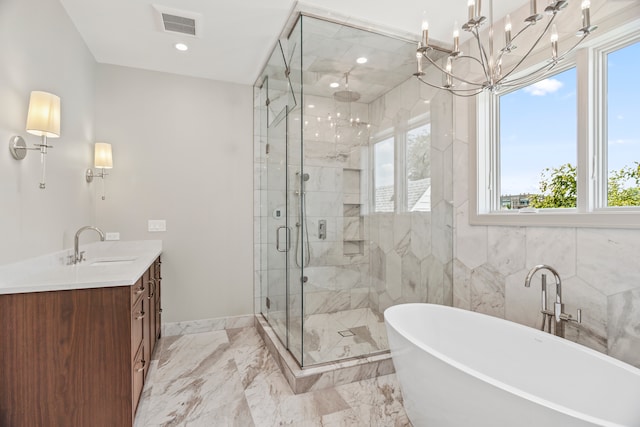 bathroom featuring plenty of natural light, shower with separate bathtub, a chandelier, and vanity