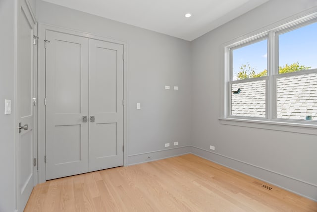 unfurnished bedroom featuring light wood-type flooring and a closet