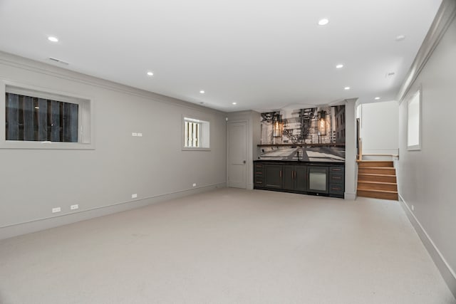 unfurnished living room featuring ornamental molding and bar