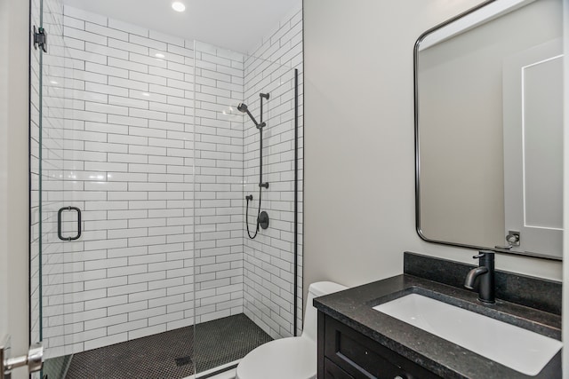 bathroom featuring an enclosed shower, toilet, and vanity