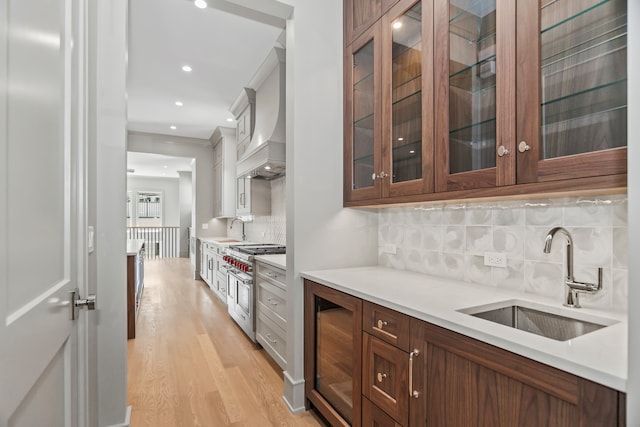 kitchen with wine cooler, backsplash, double oven range, light hardwood / wood-style floors, and custom exhaust hood