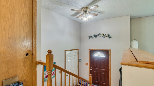 entrance foyer with ceiling fan and a textured ceiling