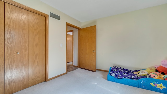 bedroom with light carpet and a closet