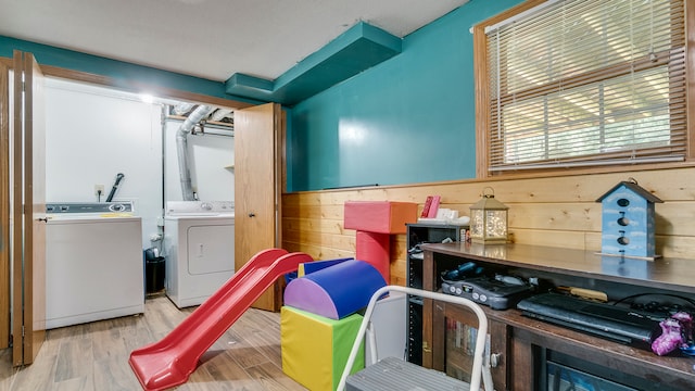 interior space featuring light hardwood / wood-style flooring, independent washer and dryer, and wooden walls