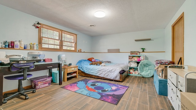 bedroom with wood-type flooring and a textured ceiling