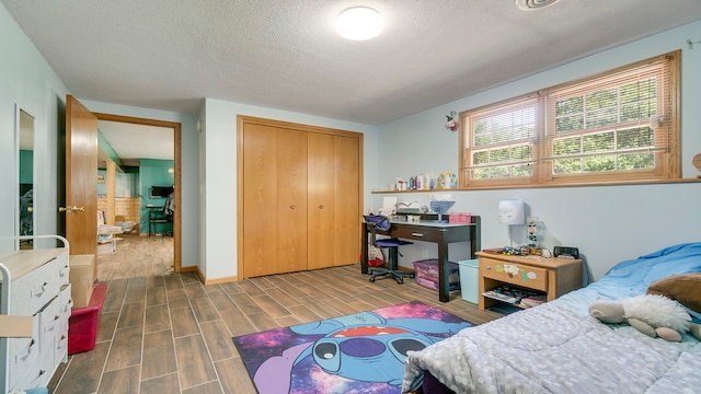 bedroom with hardwood / wood-style floors, a closet, and a textured ceiling