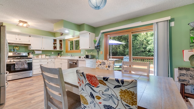 dining area featuring a textured ceiling, sink, and light hardwood / wood-style floors