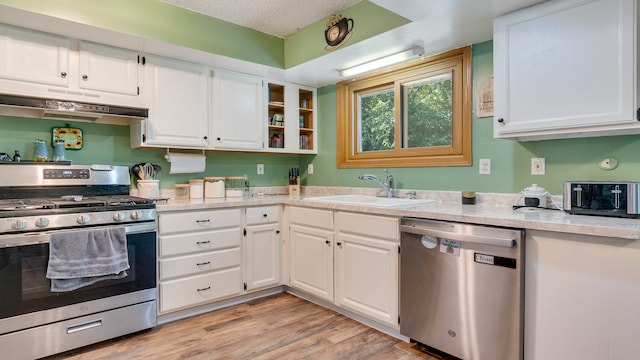 kitchen featuring light wood-type flooring, appliances with stainless steel finishes, and white cabinets