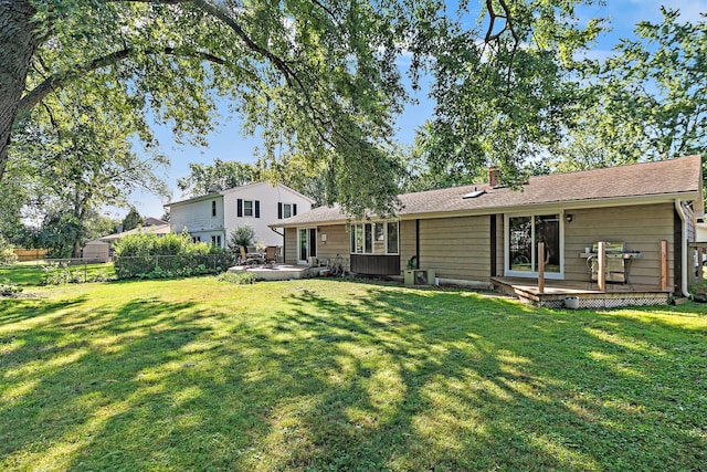 back of property featuring a lawn and a deck