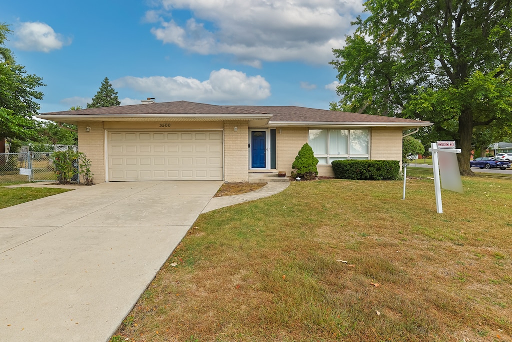 view of front of house featuring a garage and a front lawn