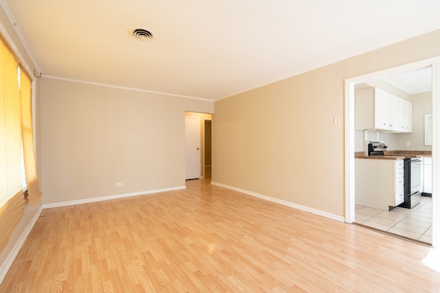 spare room featuring light hardwood / wood-style floors and ornamental molding