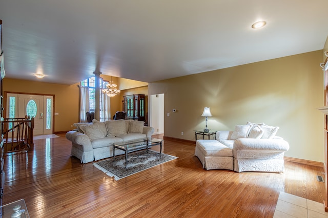 living room with an inviting chandelier and light hardwood / wood-style flooring