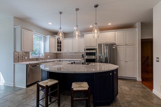 kitchen featuring white cabinets, hardwood / wood-style floors, light stone counters, stainless steel appliances, and a kitchen island