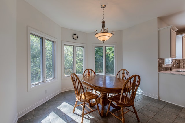 tiled dining area featuring plenty of natural light and sink