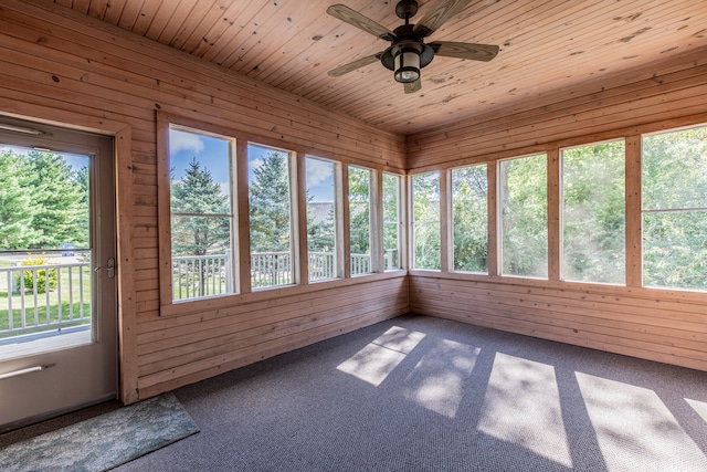 unfurnished sunroom with ceiling fan, a wealth of natural light, and wood ceiling