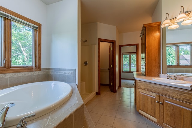 bathroom with tiled bath, vanity, and tile patterned floors