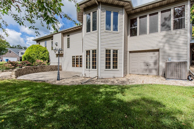 back of house with central AC, a lawn, a garage, and a patio