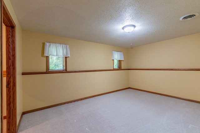 unfurnished room featuring a textured ceiling and carpet