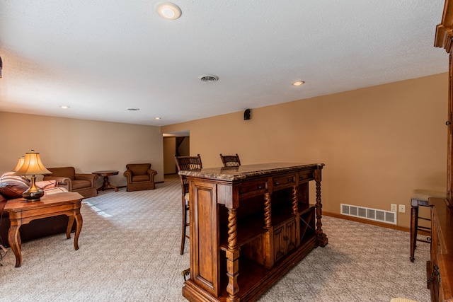 interior space with a textured ceiling and carpet flooring