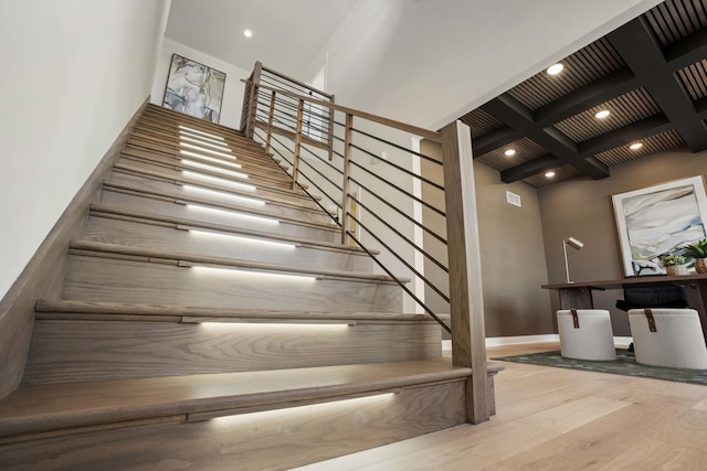stairs featuring wood finished floors, beam ceiling, baseboards, and coffered ceiling