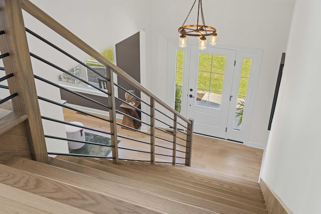 foyer entrance featuring a chandelier, stairway, and wood finished floors