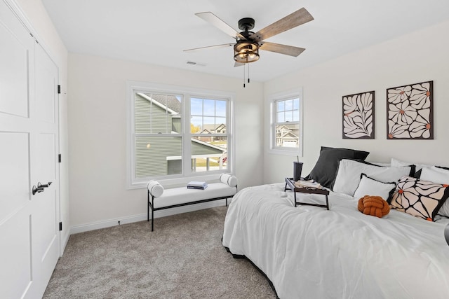bedroom with light colored carpet, ceiling fan, baseboards, and visible vents