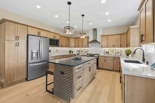 kitchen with wall chimney exhaust hood, light brown cabinetry, stainless steel appliances, and a sink