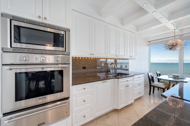 kitchen with white cabinets, sink, a water view, and appliances with stainless steel finishes