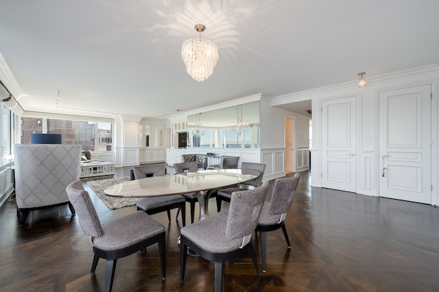 dining room featuring dark parquet flooring, a notable chandelier, and ornamental molding