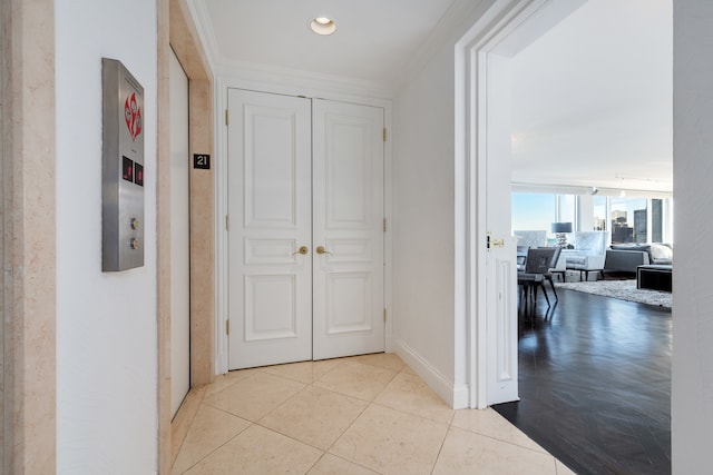 corridor with light tile patterned flooring and crown molding