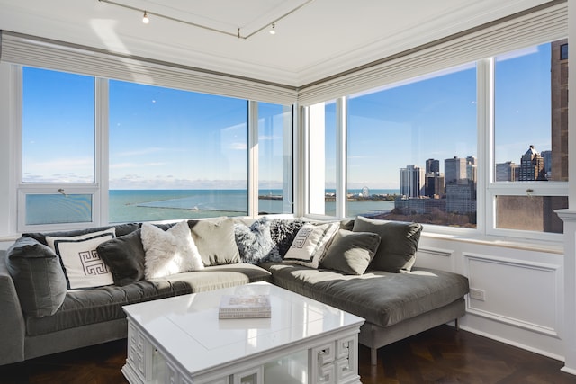 sunroom featuring a water view and track lighting