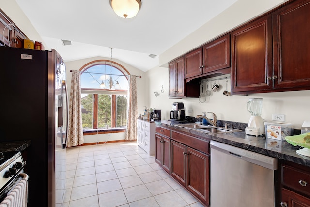 kitchen with appliances with stainless steel finishes, sink, lofted ceiling, dark stone countertops, and light tile patterned flooring