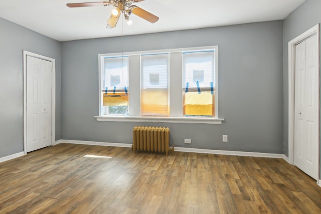 unfurnished bedroom with ceiling fan, dark hardwood / wood-style floors, and radiator