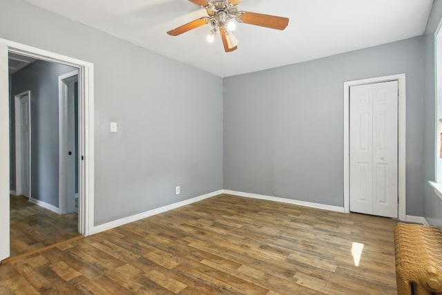 spare room with dark wood-type flooring and ceiling fan