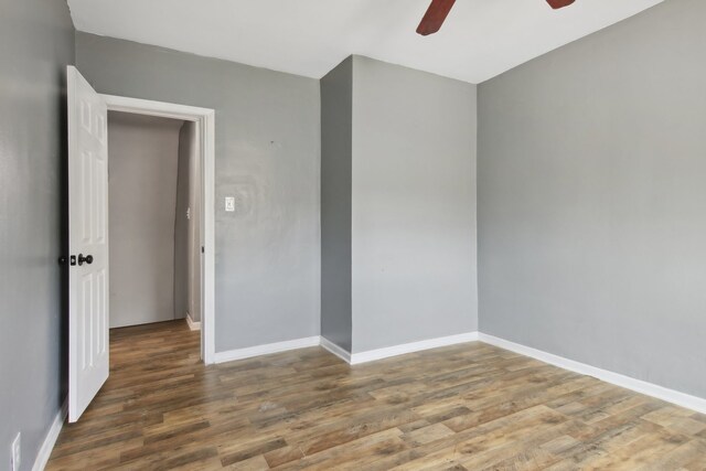 empty room with dark wood-type flooring and ceiling fan