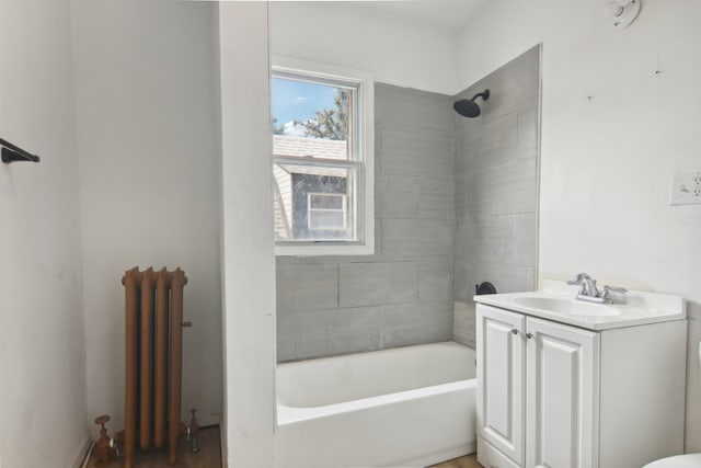 bathroom featuring tiled shower / bath combo, radiator heating unit, and vanity