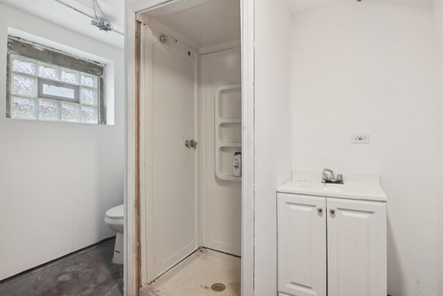 bathroom featuring vanity, toilet, and concrete floors