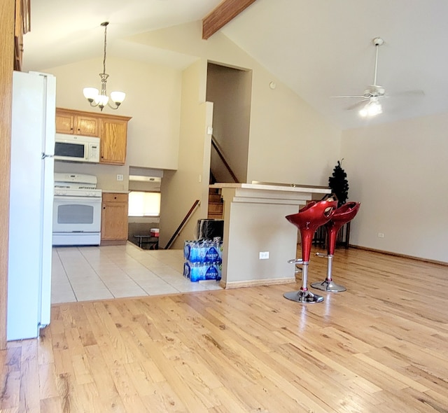 kitchen with lofted ceiling, light wood-type flooring, ceiling fan with notable chandelier, and white appliances