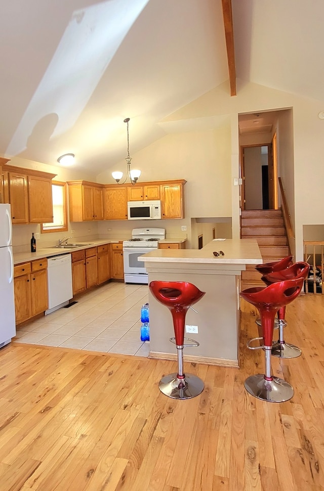 kitchen featuring light hardwood / wood-style floors, white appliances, hanging light fixtures, and a breakfast bar