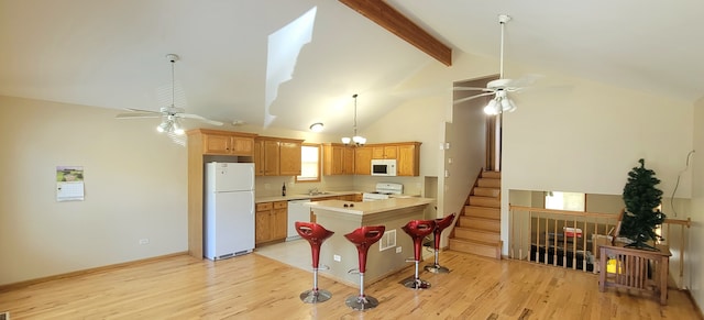 kitchen featuring light wood-type flooring, white appliances, kitchen peninsula, ceiling fan, and a kitchen bar