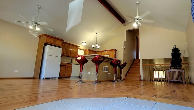 kitchen with ceiling fan with notable chandelier, white appliances, light hardwood / wood-style flooring, and high vaulted ceiling