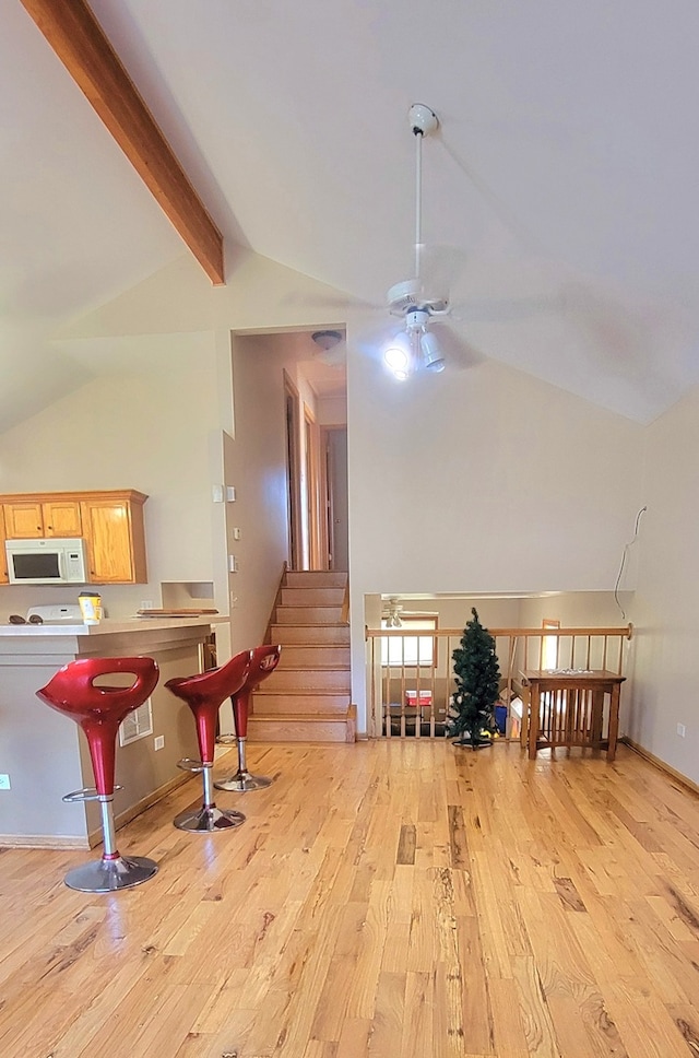 interior space with high vaulted ceiling, ceiling fan, light wood-type flooring, and beam ceiling