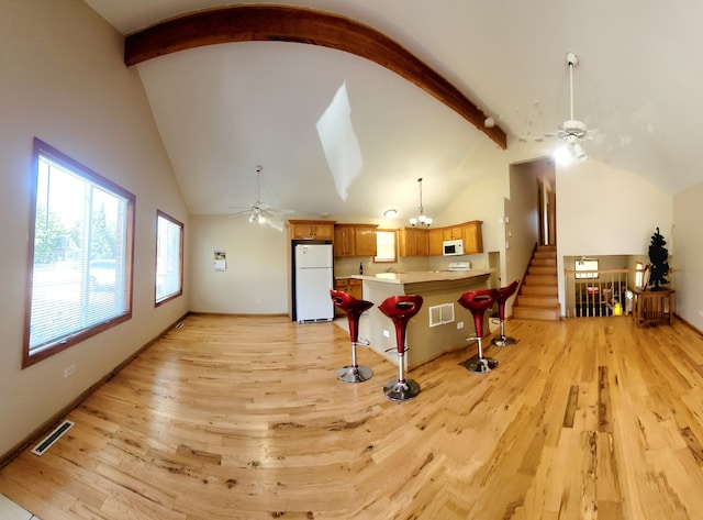 interior space featuring light wood-type flooring, ceiling fan, high vaulted ceiling, and beam ceiling