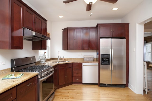 kitchen with sink, ceiling fan, stainless steel appliances, light stone countertops, and light wood-type flooring