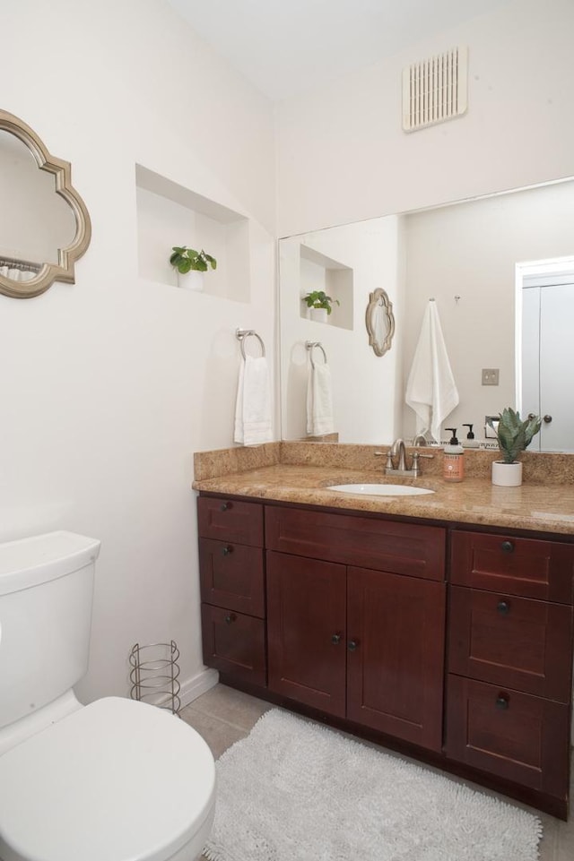 bathroom featuring vanity, tile patterned floors, and toilet